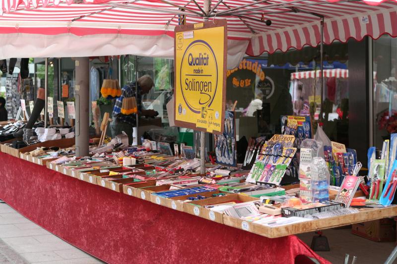 Market stall with handmade goods under a red and white awning