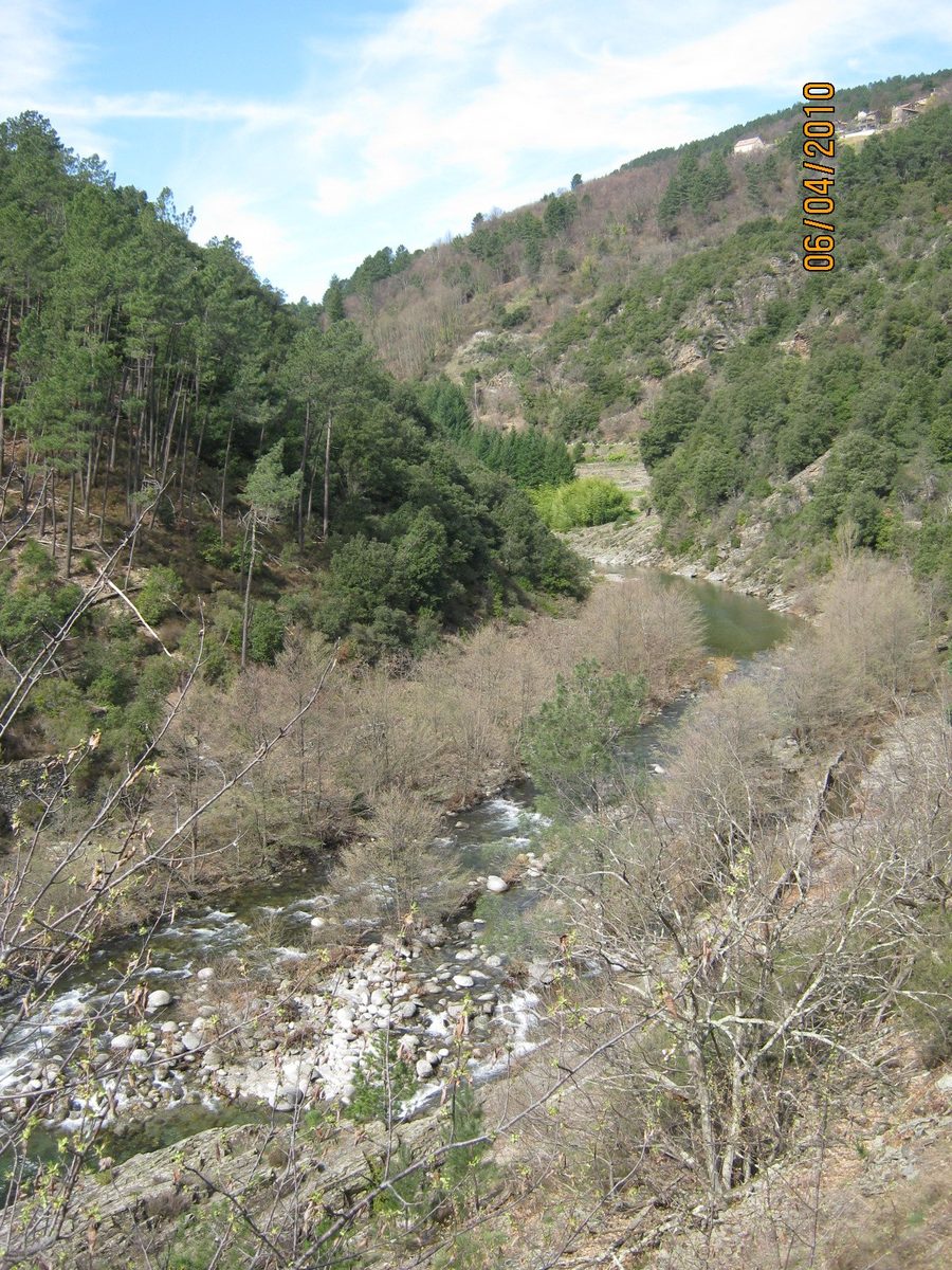 Paysage de la vallée de la Drobie en Ardèche avec des versants boisés et des maisons dispersées