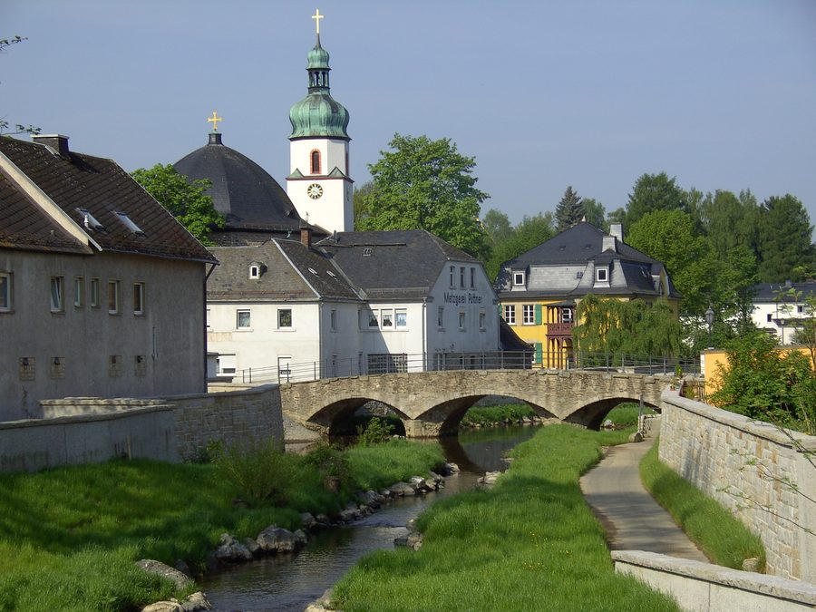 Pont au-dessus de la Schwesnitz à Oberkotzau avec l’église évangélique Saint-Jacques en arrière-plan.