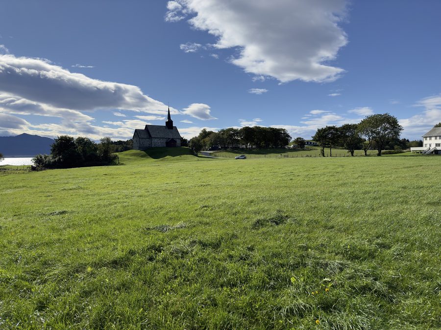Ancienne église d’Edøy avec des champs et la ferme historique d’Edøy à Edøya