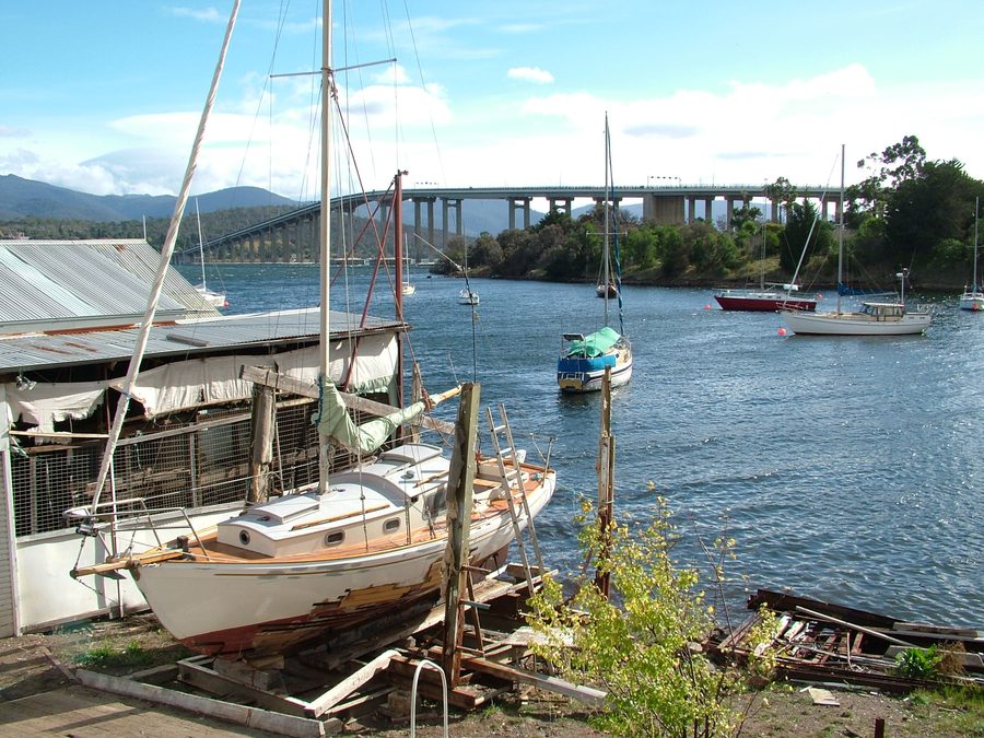 Vue sur Montagu Bay en Tasmanie avec un yacht sur cale sèche et le pont Tasman en arrière-plan