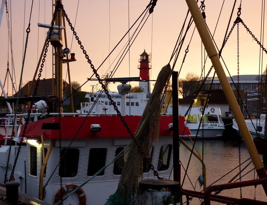Port de Büsum avec bateaux et phare au coucher du soleil