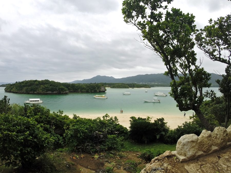 Baie de Kabira à Ishigaki avec une bande côtière claire, une eau bleue et un paysage insulaire verdoyant