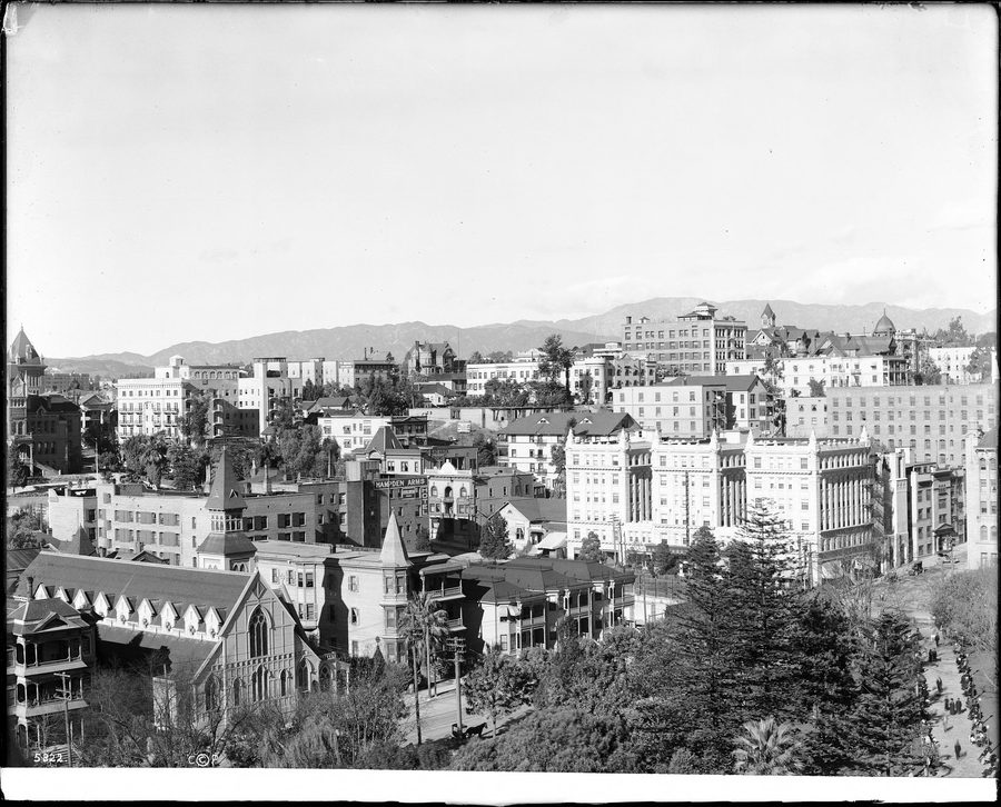 Vue panoramique sur Los Angeles avec une forte densité de bâtiments et des collines au loin.