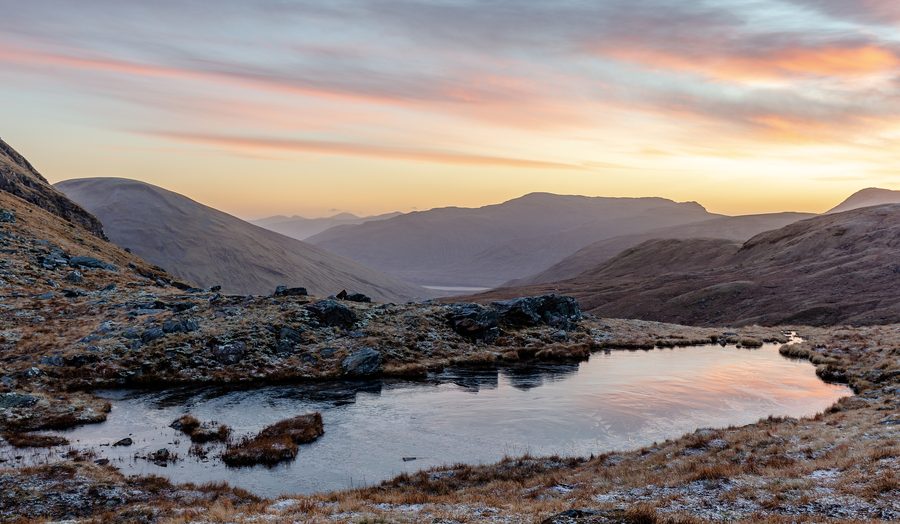 Petit lac entre les montagnes dans les Highlands écossais au lever du soleil