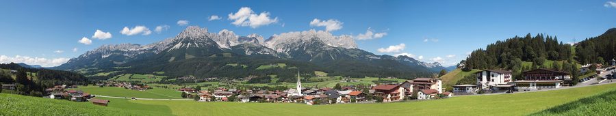 Village de montagne Ellmau avec des pentes verdoyantes et une large vallée en été.