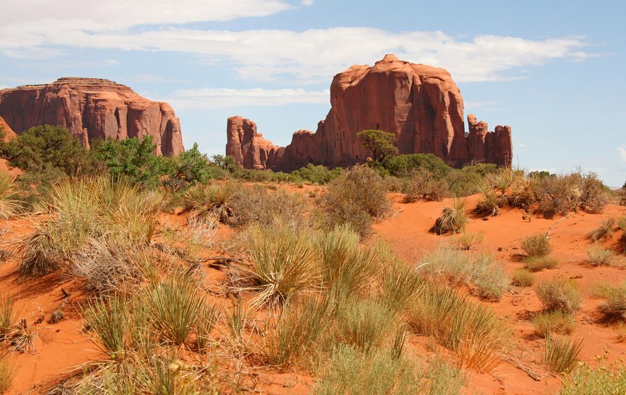 Les mesas et buttes de Monument Valley en Arizona sous un ciel bleu.
