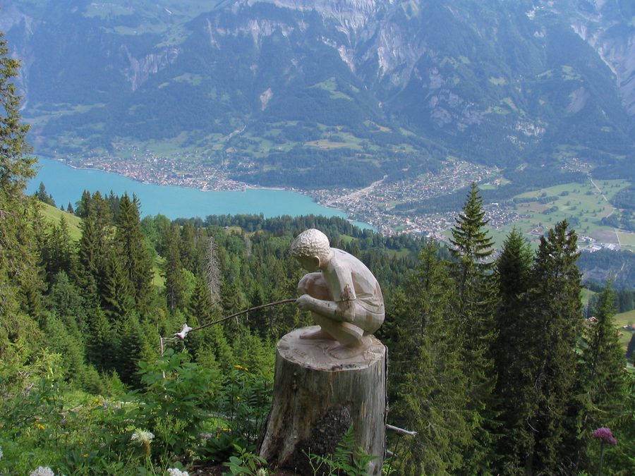 Figure en bois sculpté sur le sentier des sculpteurs de l’Axalp avec Brienz en arrière-plan
