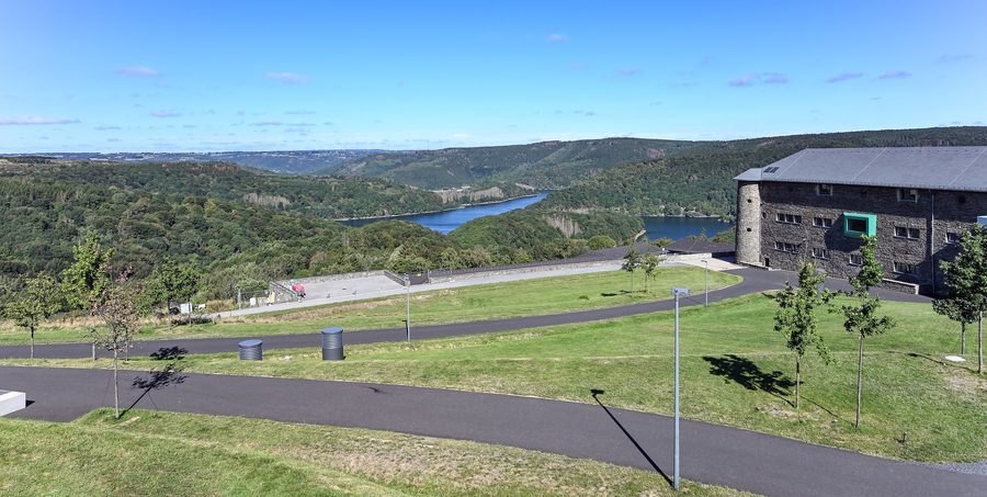 Bâtiment de l’ancienne Ordensburg Vogelsang dans le parc national de l’Eifel avec le lac de retenue de l’Urft en arrière-plan