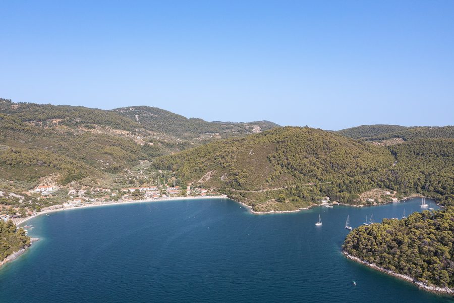 Vue aérienne de la plage de Panormos à Skopelos avec une eau turquoise et une côte boisée