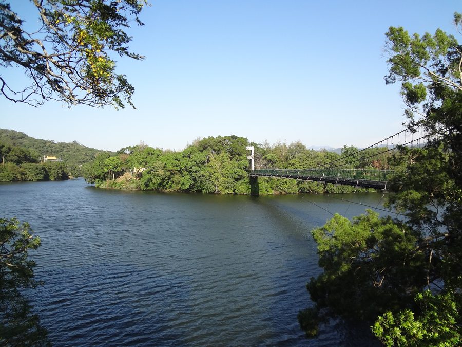 Pont suspendu au-dessus du réservoir Mingde à Touwu, entouré de montagnes verdoyantes