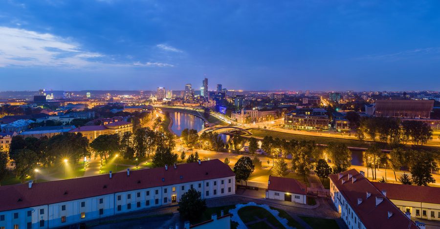 Skyline de Vilnius au crépuscule avec des bâtiments illuminés.
