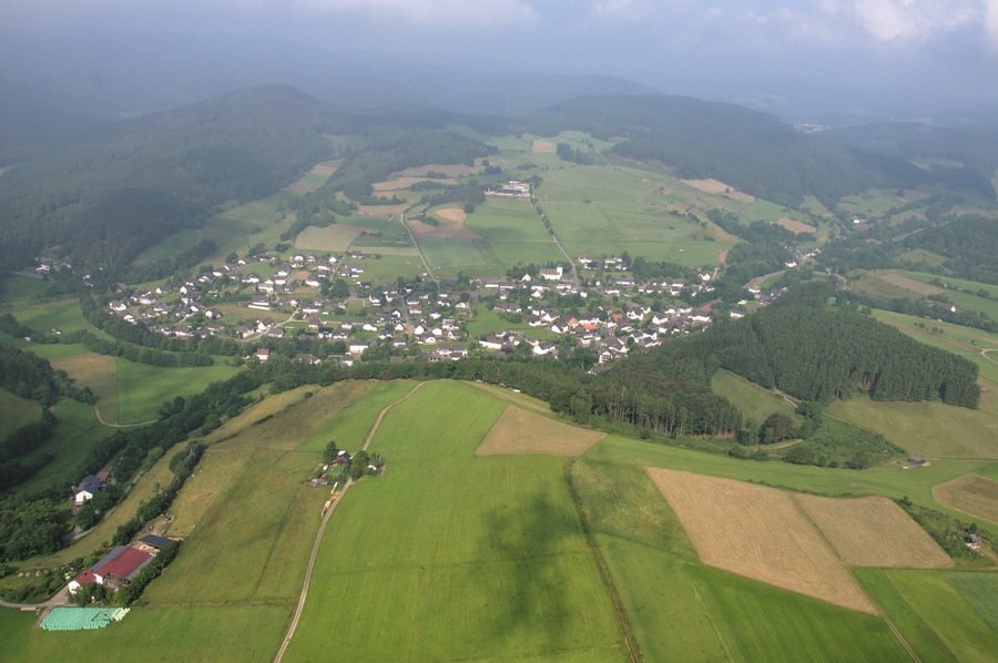 Vue aérienne de Hallenberg-Liesen avec des espaces ouverts et des versants boisés en arrière-plan