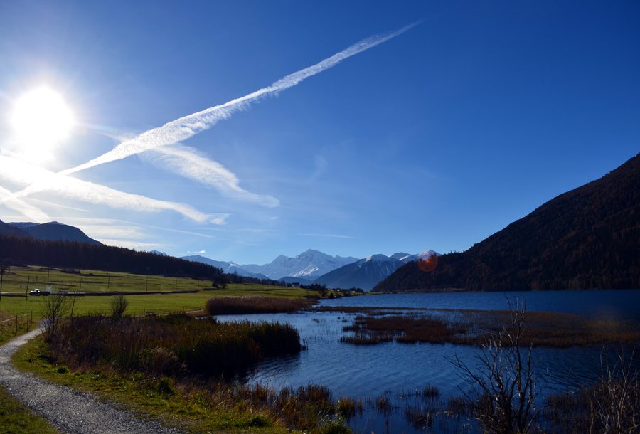 Lac de Resia entouré de montagnes alpines enneigées dans le Tyrol du Sud