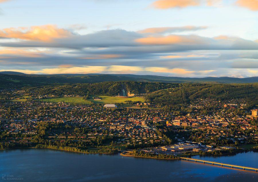Vue sur Lillehammer, avec des bâtiments regroupés le long de la vallée et les collines environnantes.