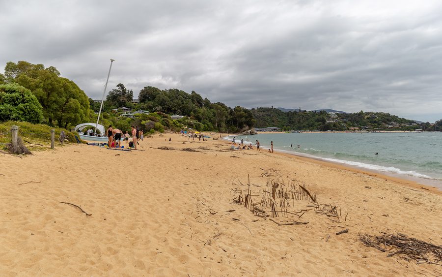 Plage de sable à Little Kaiteriteri avec une eau bleue et calme.