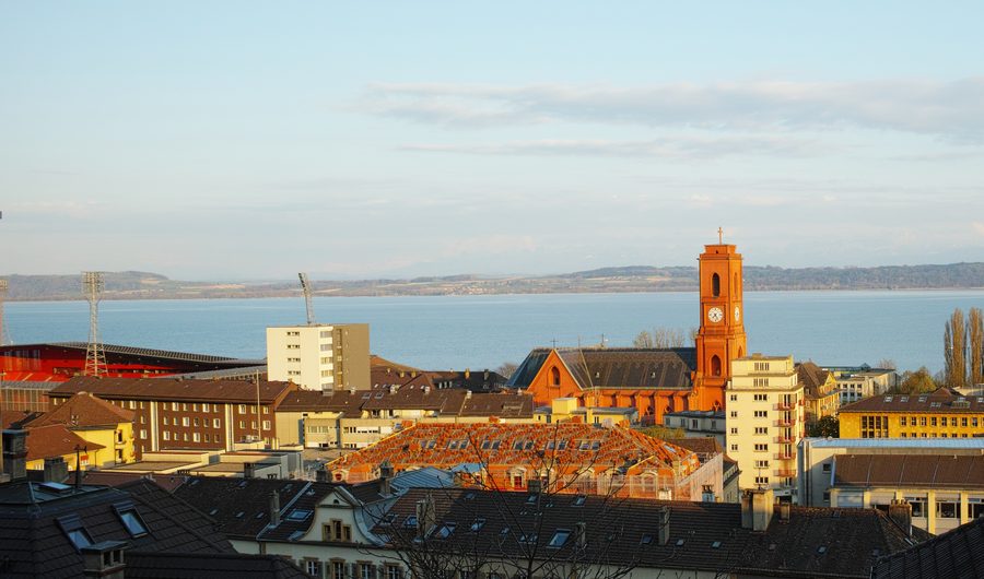 Partie de Neuchâtel avec l’église Notre-Dame-de-l’Assomption et le lac de Neuchâtel à la lumière du soir