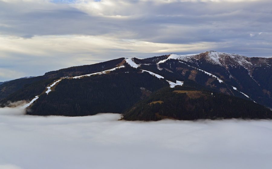 Schmittenhöhe au-dessus de Zell am See avec du brouillard couvrant le bassin, le lac et la ville