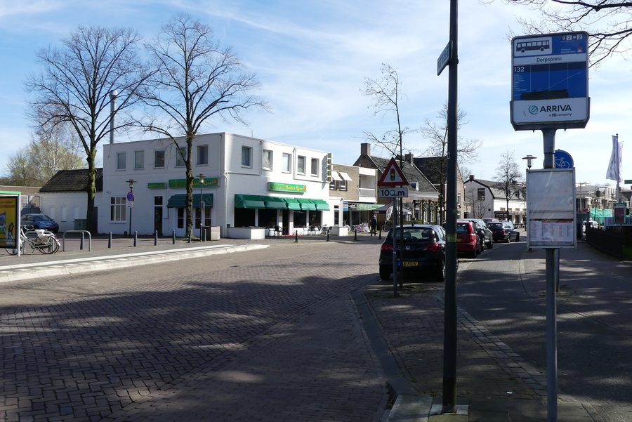 La Dorpstraat à Ulvenhout avec un arrêt de bus et un restaurant