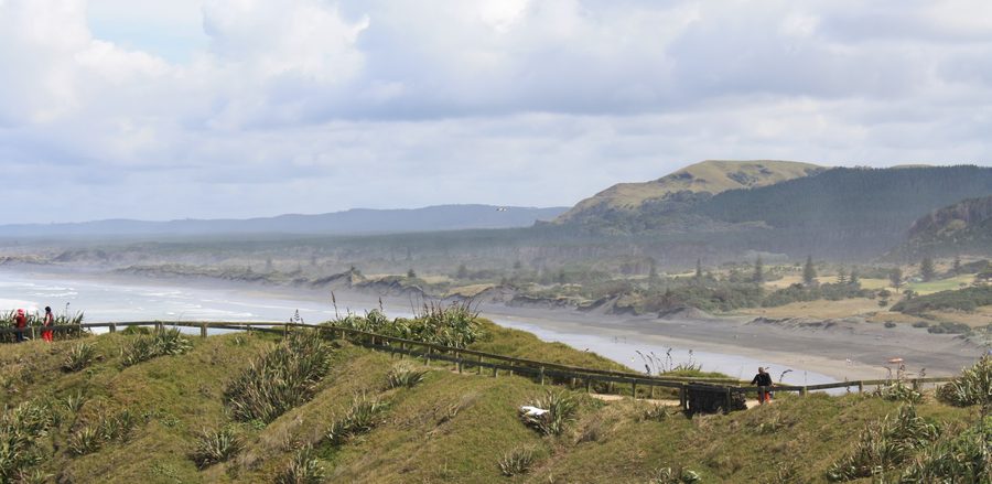 Muriwai Beach avec sable noir et côte rocheuse en Nouvelle-Zélande